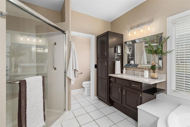 bathroom featuring tile patterned flooring, vanity, toilet, and a shower with shower door