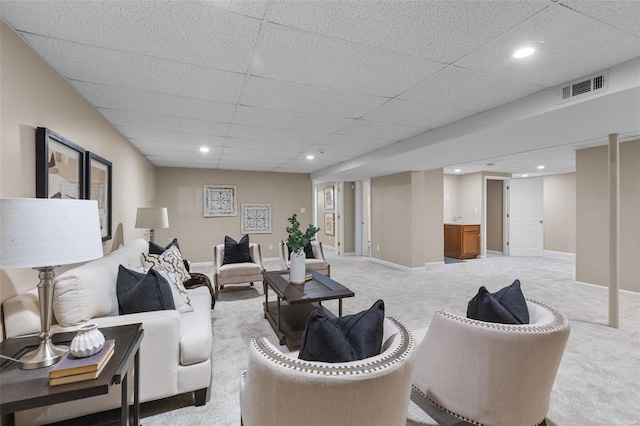 living room with a paneled ceiling and light carpet