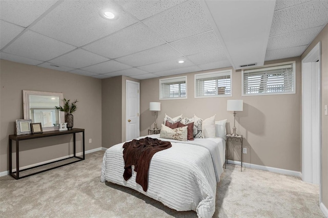 bedroom with a paneled ceiling and light carpet