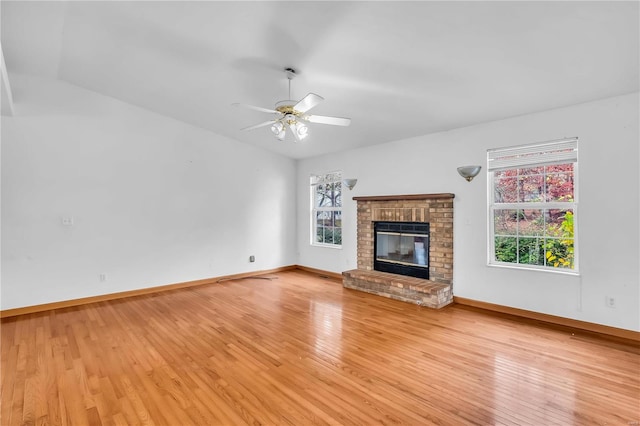 unfurnished living room with a fireplace, ceiling fan, light hardwood / wood-style flooring, and vaulted ceiling