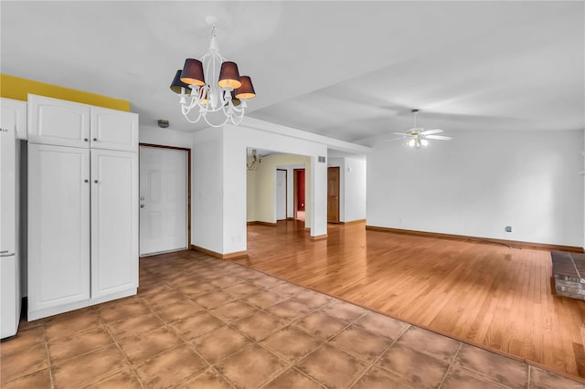 unfurnished living room featuring ceiling fan with notable chandelier