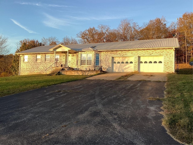 ranch-style house featuring a front yard and a garage