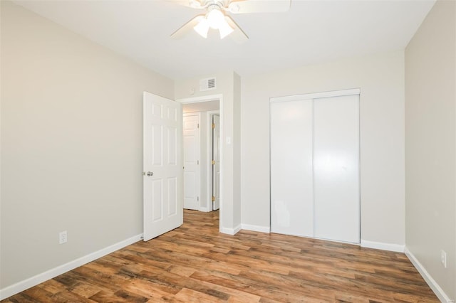 unfurnished bedroom featuring wood-type flooring, a closet, and ceiling fan