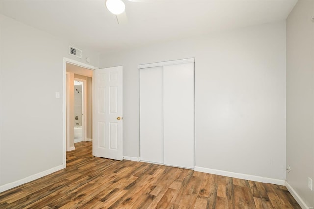 unfurnished bedroom featuring a closet and dark hardwood / wood-style flooring