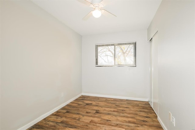 empty room with ceiling fan and dark hardwood / wood-style flooring