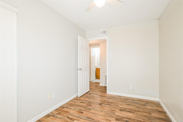 empty room with ceiling fan and light hardwood / wood-style floors