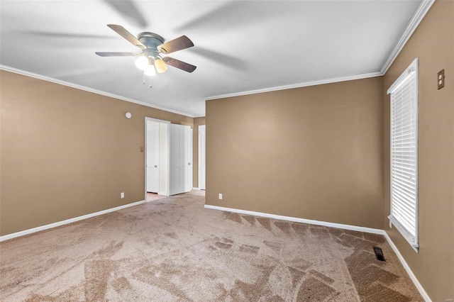 empty room with carpet floors, ceiling fan, and crown molding