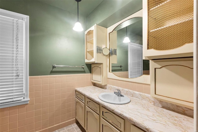 bathroom featuring tile patterned flooring, vanity, and tile walls