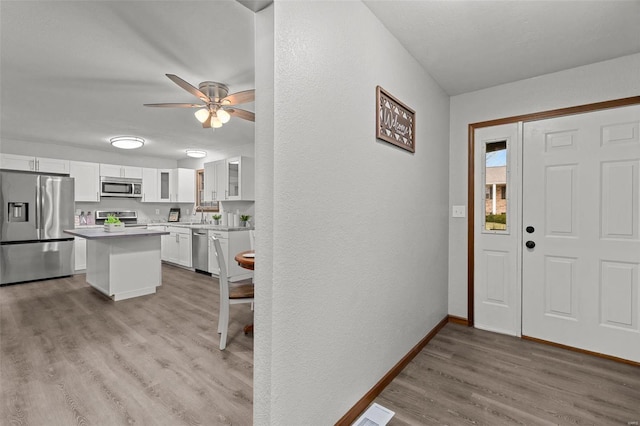 entrance foyer featuring ceiling fan, light hardwood / wood-style floors, and sink