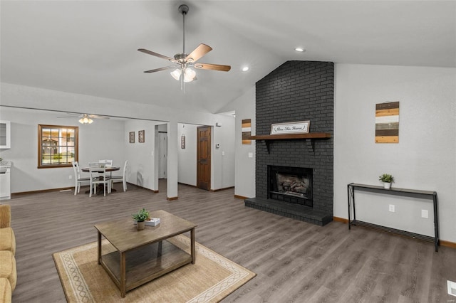 living room featuring a brick fireplace, ceiling fan, vaulted ceiling, and hardwood / wood-style flooring