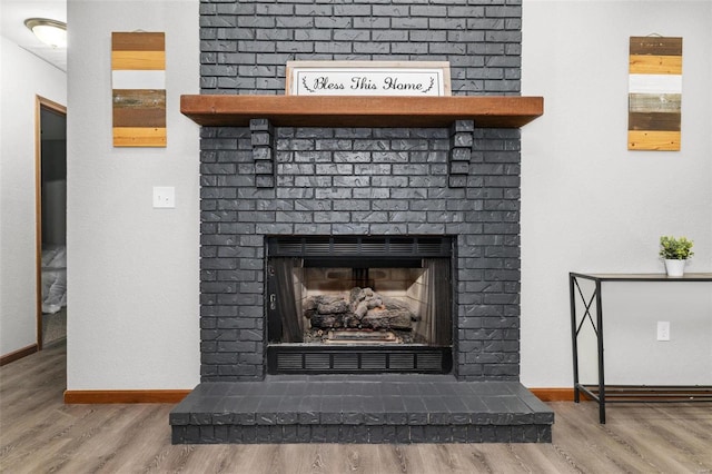 interior details with hardwood / wood-style flooring and a brick fireplace