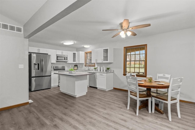 kitchen featuring white cabinets, a center island, light hardwood / wood-style floors, and appliances with stainless steel finishes