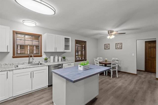 kitchen featuring ceiling fan, dishwasher, sink, light hardwood / wood-style floors, and white cabinets