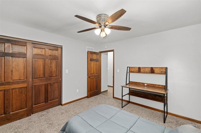 carpeted bedroom with ceiling fan and a closet