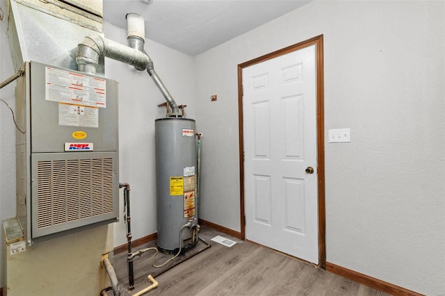 utility room with heating unit and water heater