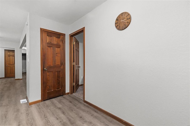 hallway with light hardwood / wood-style flooring