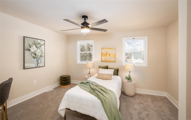 carpeted bedroom featuring ceiling fan and multiple windows