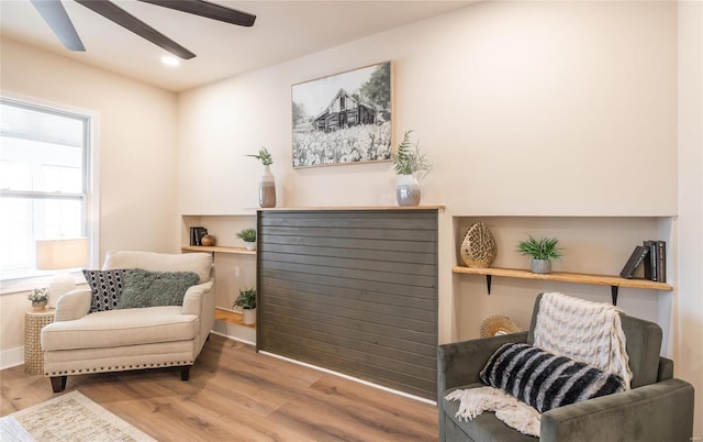 living area featuring hardwood / wood-style floors and ceiling fan