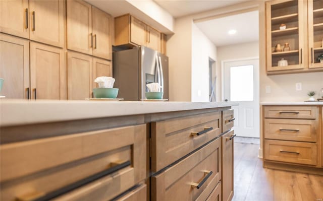 kitchen with light brown cabinets, stainless steel fridge, and light wood-type flooring