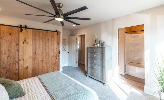 bedroom with carpet floors, a barn door, and ceiling fan