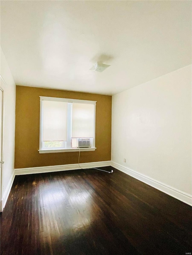 empty room featuring dark hardwood / wood-style floors and cooling unit