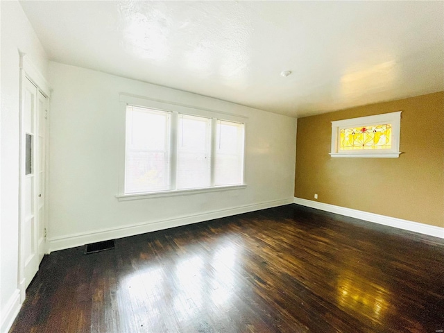 unfurnished room with dark hardwood / wood-style flooring