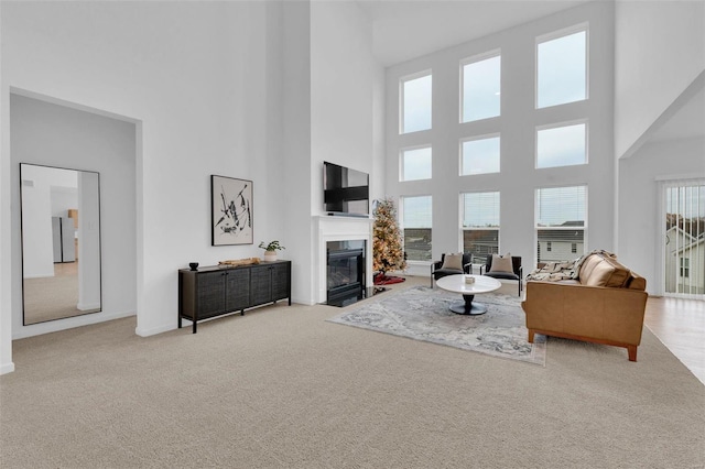 living room with a high ceiling and light colored carpet