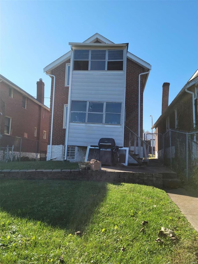 rear view of house with a patio area and a lawn