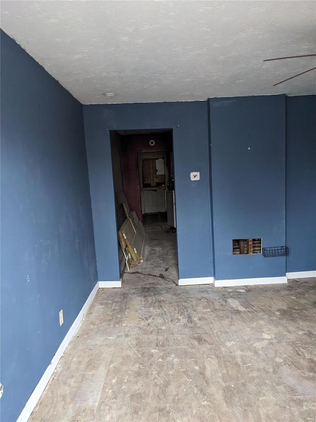 unfurnished room with a textured ceiling