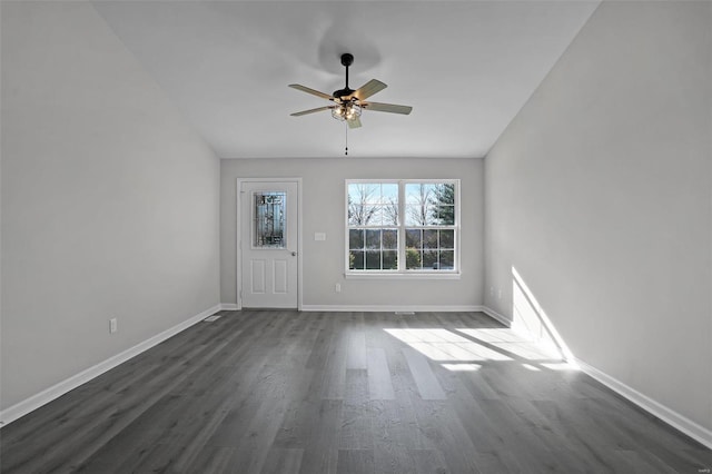 empty room with vaulted ceiling, ceiling fan, and dark hardwood / wood-style floors