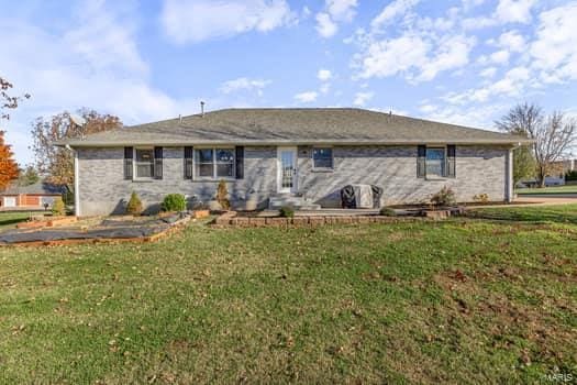 back of house with a lawn