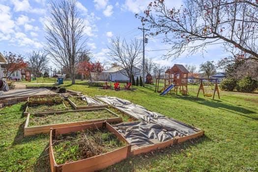 view of play area with a trampoline and a yard