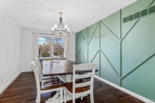 dining room with dark wood-type flooring and a chandelier