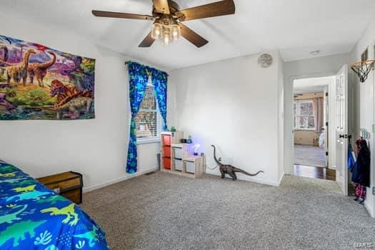 bedroom featuring carpet, multiple windows, and ceiling fan