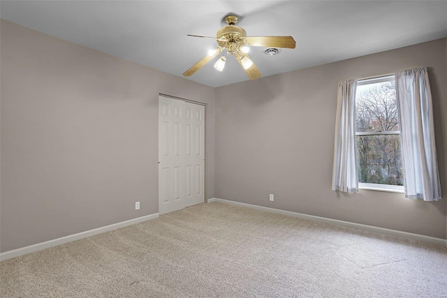 carpeted empty room featuring ceiling fan