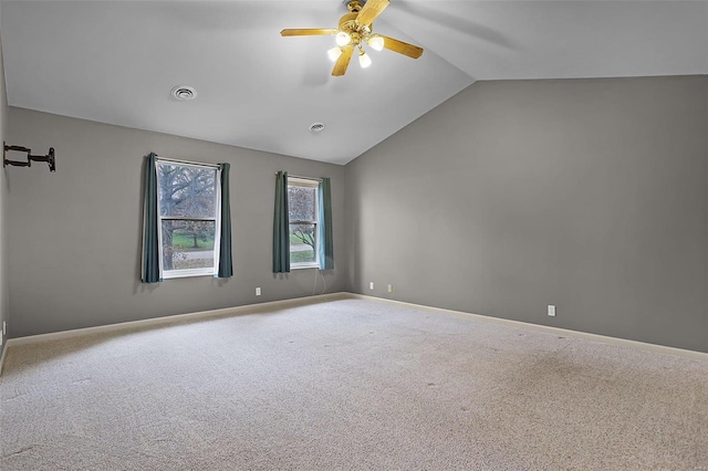 carpeted spare room with ceiling fan and lofted ceiling