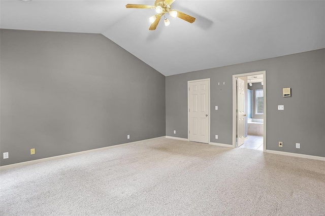 spare room featuring light colored carpet, ceiling fan, and lofted ceiling