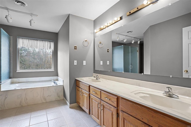 bathroom with tile patterned flooring, a bath, and vanity