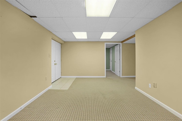 carpeted spare room featuring a paneled ceiling