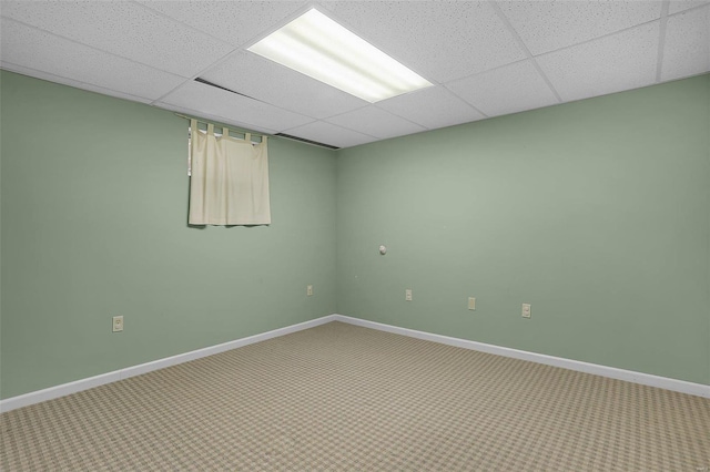 carpeted spare room with a drop ceiling