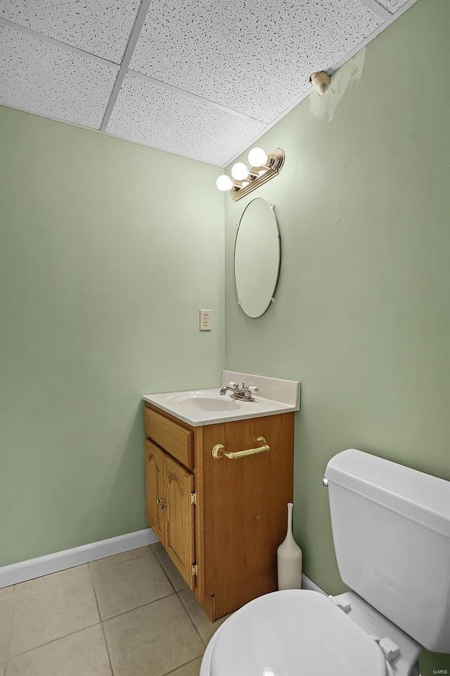 bathroom featuring a paneled ceiling, vanity, toilet, and tile patterned floors