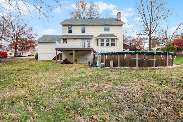 back of house with a lawn and a pool side deck