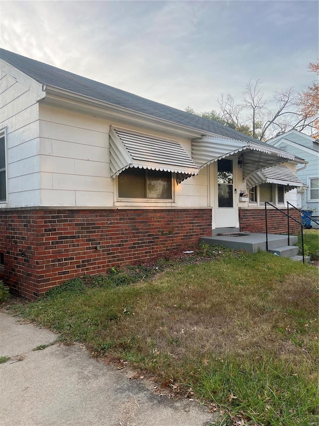 view of side of home with a lawn