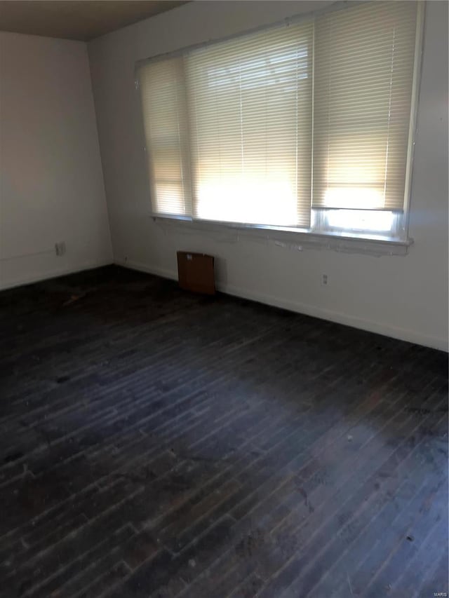 empty room with dark hardwood / wood-style flooring