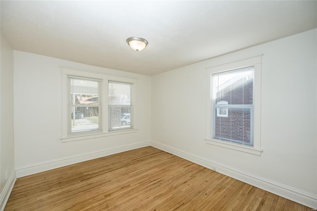 unfurnished room featuring a wealth of natural light and wood-type flooring