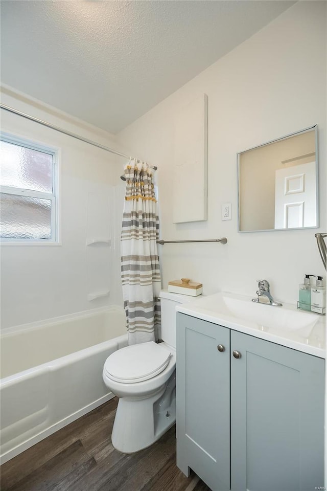 full bathroom featuring shower / bath combo, wood-type flooring, a textured ceiling, toilet, and vanity