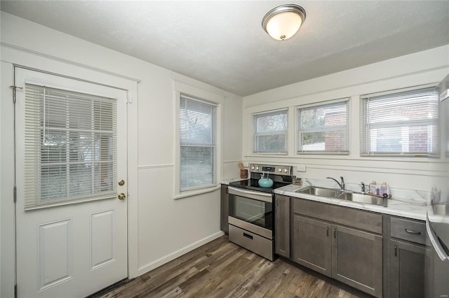 kitchen with stainless steel electric stove, dark hardwood / wood-style floors, sink, and a textured ceiling