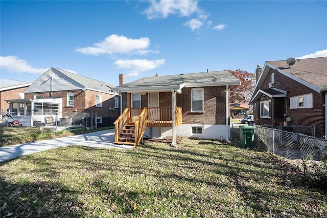 rear view of property featuring a lawn