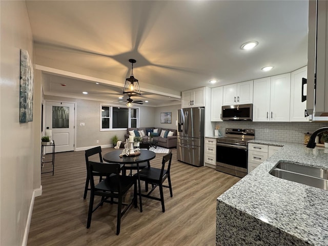 kitchen featuring stainless steel appliances, white cabinetry, ceiling fan, and sink