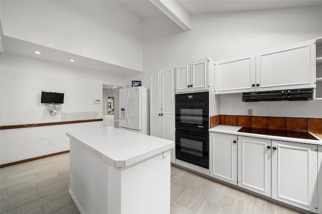 kitchen featuring a center island, high vaulted ceiling, black appliances, beamed ceiling, and white cabinetry